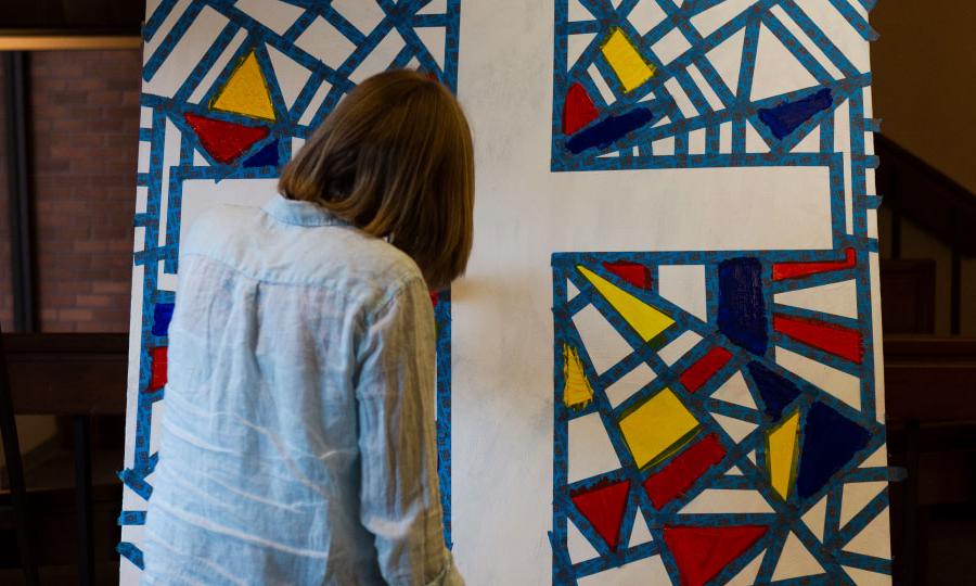 student painting a cross